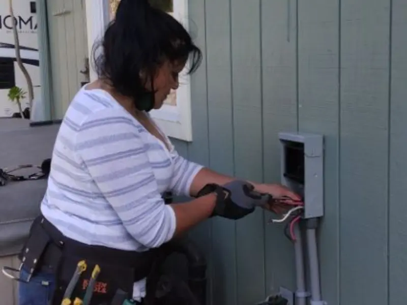 Licensed electrician wiring an exterior subpanel in Bozeman